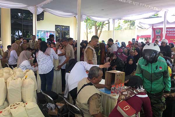 Animo masyarakat antri dengan tertib mendapatkan paket sembako seharga Rp50 ribu. (wul) - Pasar Murah Lima Kecamatan Siapkan 10.375 Paket Sembako untuk RTM dan MBR
