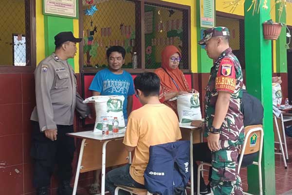 Babinsa Koramil 0833/02 Kedungkandang dampingi pendistribuan bantuan pangan warga Mergosono. (ist) - Babinsa Koramil 0833/02 Kedungkandang Dampingi Pendistribuan Bantuan Pangan Warga Mergosono