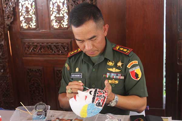 Dandim 0833/Kota Malang mewarnai Topeng dalam International Mask Festival 2023. (ist) - Dandim 0833/Kota Malang Berikan Dukungan International Mask Festival 2023