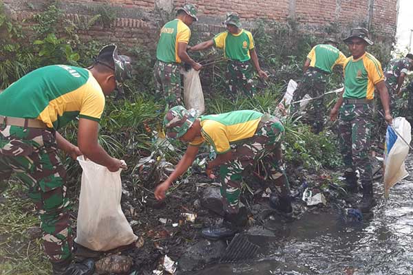Personel Koramil Sukun bersama warga bersihkan bantaran Sungai Kutuk. (ist) - Personel Koramil Sukun Bersama Warga Bersihkan Bantaran Sungai Kutuk