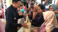 Pj Wali Kota Malang turut menyerahkan paket sembako dalam operasi pasar murah di Kecamatan Kedungkandang. (wul) - Pasar Murah Lima Kecamatan Siapkan 10.375 Paket Sembako untuk RTM dan MBR