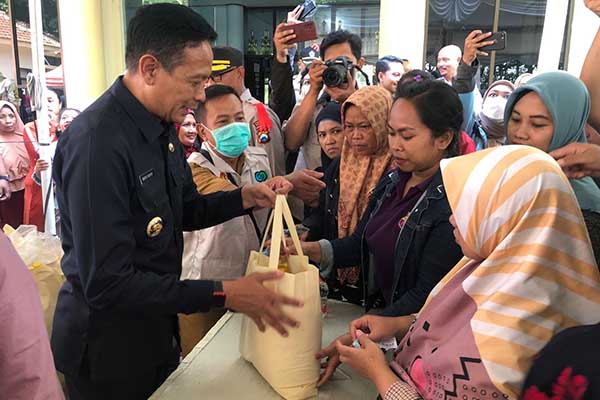 Pj Wali Kota Malang turut menyerahkan paket sembako dalam operasi pasar murah di Kecamatan Kedungkandang. (wul) - Pasar Murah Lima Kecamatan Siapkan 10.375 Paket Sembako untuk RTM dan MBR