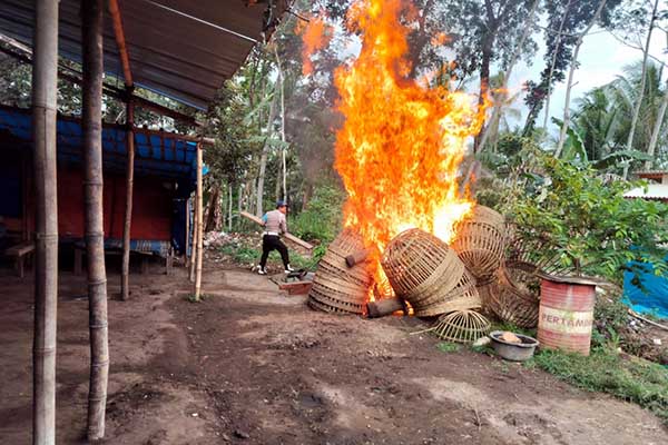 Proses pembakaran barang-barang yang digunakan untuk berjudi sabung ayam. (ist) - Polsek Bantur Gerebek dan Musnahkan Gelanggang Judi Sabung Ayam