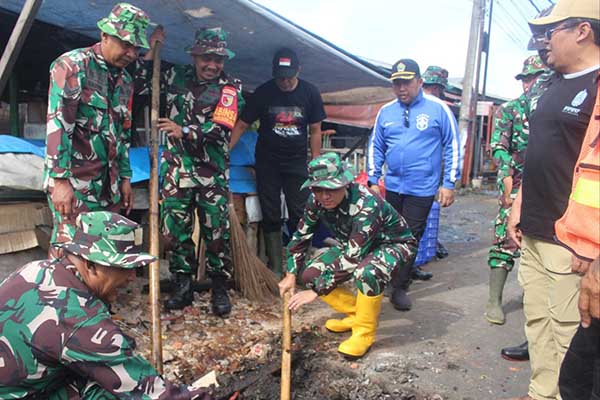Dandim 0833/Kota Malang membersihkan drainase yang tersumbat di Pasar Gadang. (ist) - Kodim 0833/Kota Malang Karya Bakti Pembersihan Drainase dan Penanaman Pohon