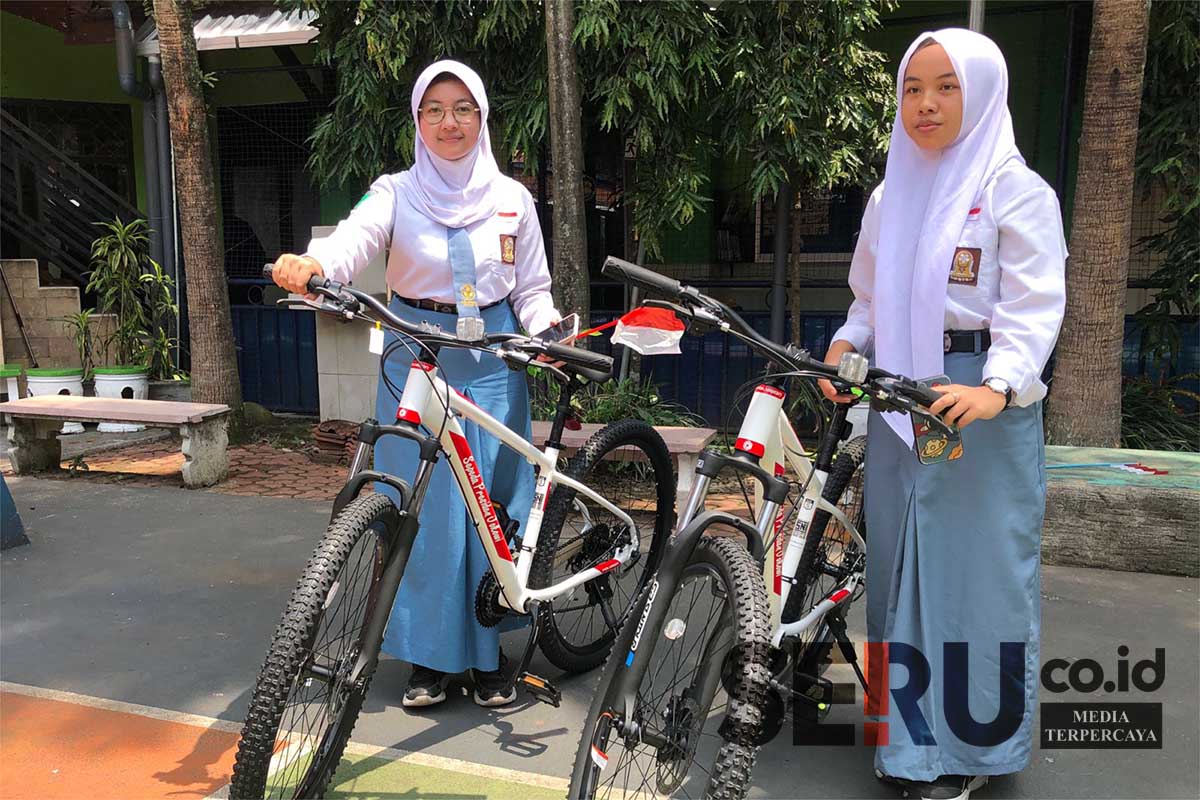 Kedua siswi dan sepeda yang mereka dapat dari Presiden RI. (Seru co.id/wul) - Dua Siswi SMK Negeri 3 Malang Dapat Sepeda dari Presiden RI