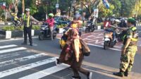 Babinsa Blimbing bantu penyebrangan siswa SMP Kartika IV-8 Malang. (ist) - Babinsa Blimbing Bantu Penyebrangan Siswa SMP Kartika IV-8 Malang