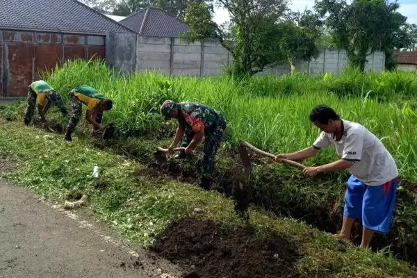 Babinsa Kedungkandang Karya Bhakti Bersihkan Saluran Air