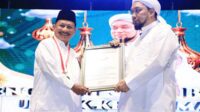 Piagam penghargaan Rekor MURI diberikan kepada Bupati Situbondo dan Pengasuh Ponpes Salafiyah Syafi'iyah Sukorejo. (Seru.co.id/mzm) - Jumlah Peserta Pembacaan Dzikir Basmalah di Situbondo Pecahkan Rekor MURI