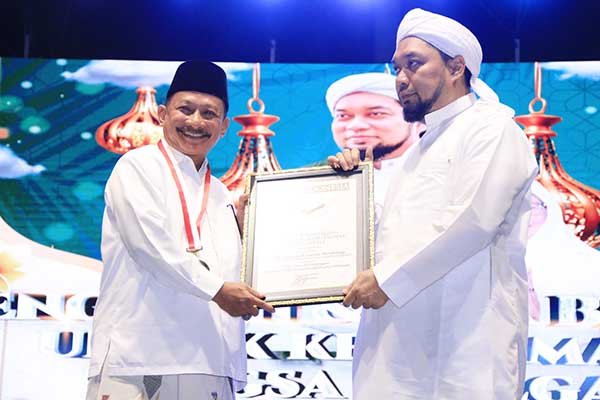 Piagam penghargaan Rekor MURI diberikan kepada Bupati Situbondo dan Pengasuh Ponpes Salafiyah Syafi'iyah Sukorejo. (Seru.co.id/mzm) - Jumlah Peserta Pembacaan Dzikir Basmalah di Situbondo Pecahkan Rekor MURI