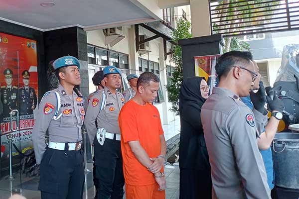 Tersangka pelaku mutilasi hanya bisa tertunduk saat rilis kejadian di Polresta Makota. (ws10) - Motif Mutilasi Sawojajar, Terapis Kesal Dianggap Ilmu Peletnya Tak Manjur
