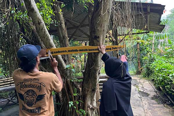 Pemasangan plang quotes oleh anggota kelompok 20(kanan) dan dibantu oleh pemuda setempat (kiri) - Quotes Bukan Sembarang Pemanis: Mahasiswa UMM PMM Kelompok 20 Gelombang 6 Niat Bangun Vibes Positif untuk Wisatawan