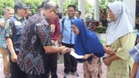 Pj. Wali Kota Batu menyerahkan secara simbolis, Kupon Penukaran sembako murah. (ist) - Melihat Animo Masyarakat, Operasi Pasar Sembako Bakal Ditambah