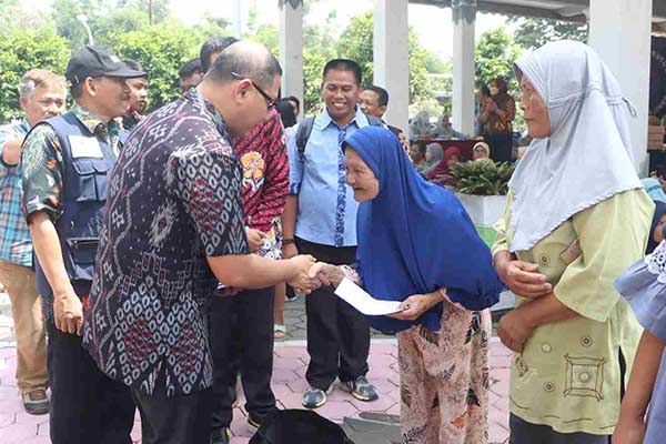 Pj. Wali Kota Batu menyerahkan secara simbolis, Kupon Penukaran sembako murah. (ist) - Melihat Animo Masyarakat, Operasi Pasar Sembako Bakal Ditambah