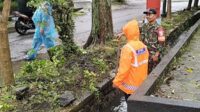 Babinsa Koramil Lowokwaru bersama DLH bersihkan saluran drainase Jatimulyo. (ist) - Babinsa Koramil Lowokwaru Bersama DLH Bersihkan Saluran Drainase Jatimulyo