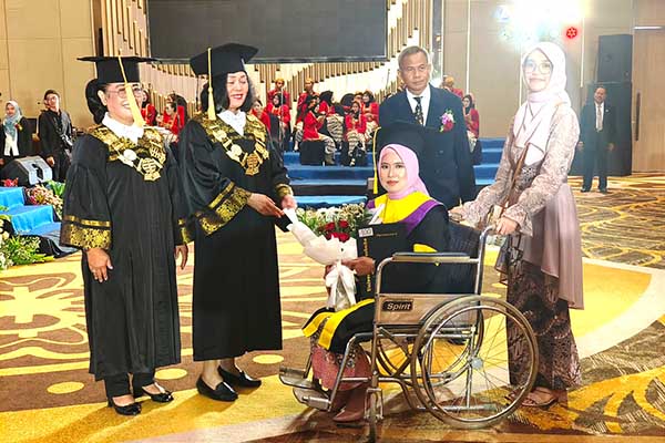 Ketua LPPM UT Pusat didampingi Direktur UT Malang, memberikan ijazah kelulusan kepada mahasiswa disabilitas. (ist) - Universitas Terbuka Malang Mewisuda 1.363 Wisudawan