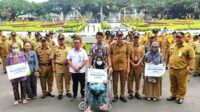 Pj Wali Kota Malang dan BPJS Ketenagakerjaan bersama para ahli waris penerima manfaat program BPJamsostek. (rhd) - Pj Wali Kota Malang Apresiasi Penghargaan BPJS Ketenagakerjaan, Dispussipda dan Satpol-PP
