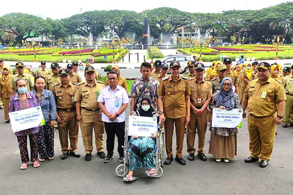 Pj Wali Kota Malang dan BPJS Ketenagakerjaan bersama para ahli waris penerima manfaat program BPJamsostek. (rhd) - Pj Wali Kota Malang Apresiasi Penghargaan BPJS Ketenagakerjaan, Dispussipda dan Satpol-PP