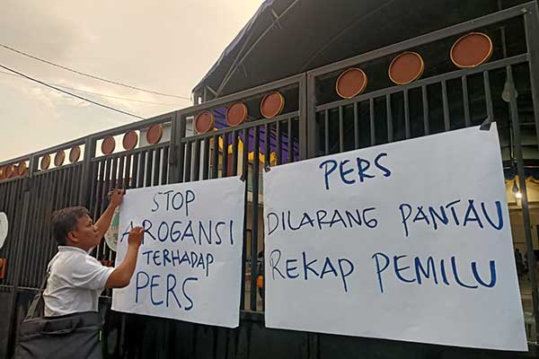 Sejumlah wartawan melakukan protes dengan menempelkan tulisan yang berisi kekecewaan terhadap KPU. (Seru.co.id/udi) - KPU Pamekasan Cegah Wartawan Liputan Rekapitulasi Penghitungan Tingkat Kabupaten