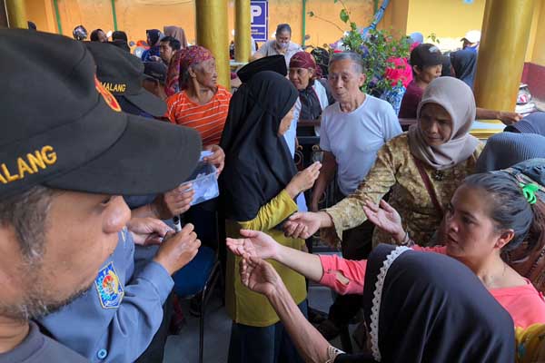 Warga tengah mengantri kupon antrean. (wul) - Pj Wali Kota Malang Gelontorkan 5 Ton Beras SPHP Bagi Warga Arjowinangun Kedungkandang
