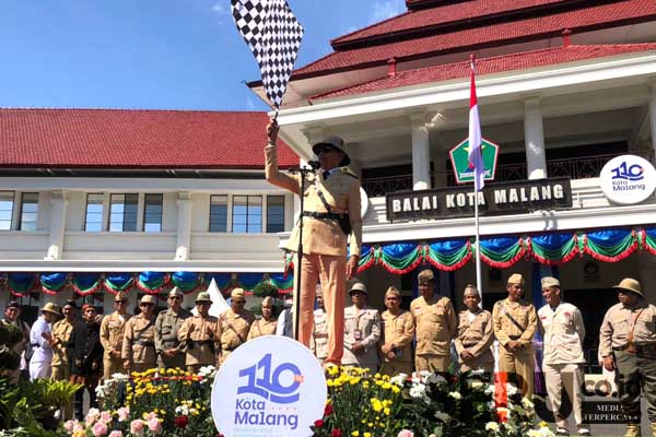 Pj Wali Kota Malang dan sang istri mengenakan pakaian kolonial beserta para OPD Kota Malang berjalan kaki mengikuti Pawai Budaya. (wul) - Merawat Sejarah, Pj Wali Kota Malang Bersama OPD dan Masyarakat Pawai Budaya Usung Kolaborasi Kuno-Kini