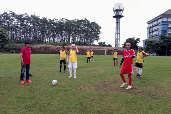 Pj Wali Kota Malang menendang bola sebagai simbolis simulasi pertandingan antar legend. (afi) - Pj Wali Kota Malang Apresiasi Pertandingan Antar Legend Malang Raya dan Surabaya, untuk Perdamaian dan Kemanusiaan