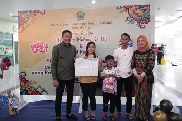 Pj Wali Kota Malang secara simbolis memberikan KTP yang selesai diurus di MOG. (afi) - Adminduk di MOG, Pj Wali Kota Malang: Jemput Bola Layani Masyarakat di Hari Libur