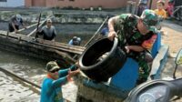 Babinsa Koramil Sukun Bersihkan Sampah di Saluran Irigasi Bersama Warga Kebonsari