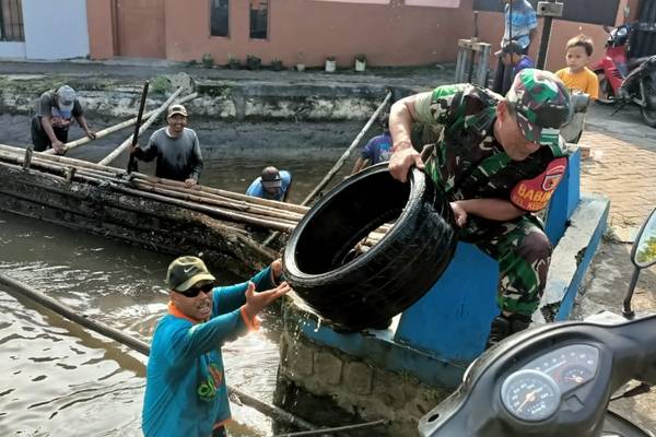 Babinsa Koramil Sukun Bersihkan Sampah di Saluran Irigasi Bersama Warga Kebonsari