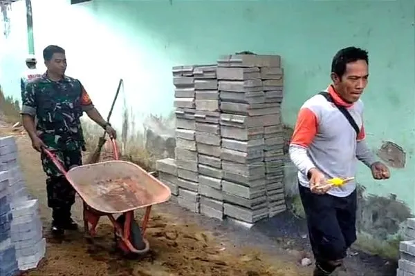 Babinsa dan Warga Mulyorejo Gotong Royong Pasang Paving di Gang Makam