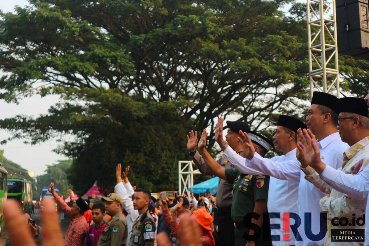 Pj Wali Kota Malang melambaikan tangan selamat jalan kepada calon jemaah haji Kota Malang. (ws11) - Pj Wali Kota Berangkatkan 721 CJH Kloter 21-22, Titip Doa Keberkahan Kota Malang