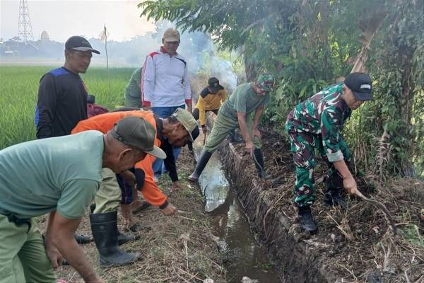 Babinsa Sukun Bersama Warga Gotong Royong Bersihkan Selokan di Jalan Tanjung Priok