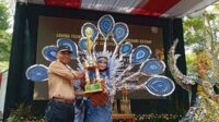 Kepala DLH Jombang ketika menyerahkan Tropi Pemenang Fashion Show. (Seru.co.id/ful) - DLH Jombang Gelar Fashion Show di Puncak Peringatan Hari Lingkungan Hidup