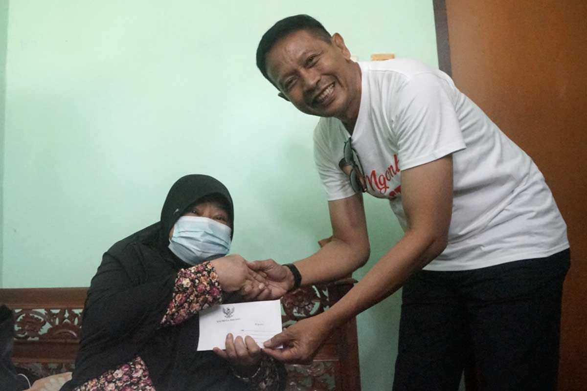 Pj Wali Kota Malang menyerahkan bantuan sosial kepada salah satu warga yang membutuhkan. (diskominfo) - Pj Wali Kota Malang Beserta Jajaran Gayeng dan Sehat Bersama Warga dalam NGOMBE STMJ