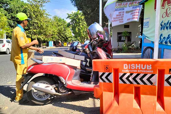 Para pemohon carut marut memarkirkan kendaraannya di bahu jalan dengan sembarangan. (Seru.co.id/mam) - Tempat Parkir Disdukcapil Situbondo Dikeluhkan Pemohon, Pentingkan Mobil dan Motor Dinas