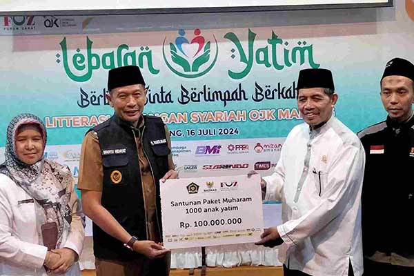 Pj Wali Kota Malang bersama Ketua Baznas menyerahkan santunan. (afi) - Rayakan Muharram 1446 H, Pj Wali Kota Malang Apresiasi Kegiatan 'Lebaran Yatim'