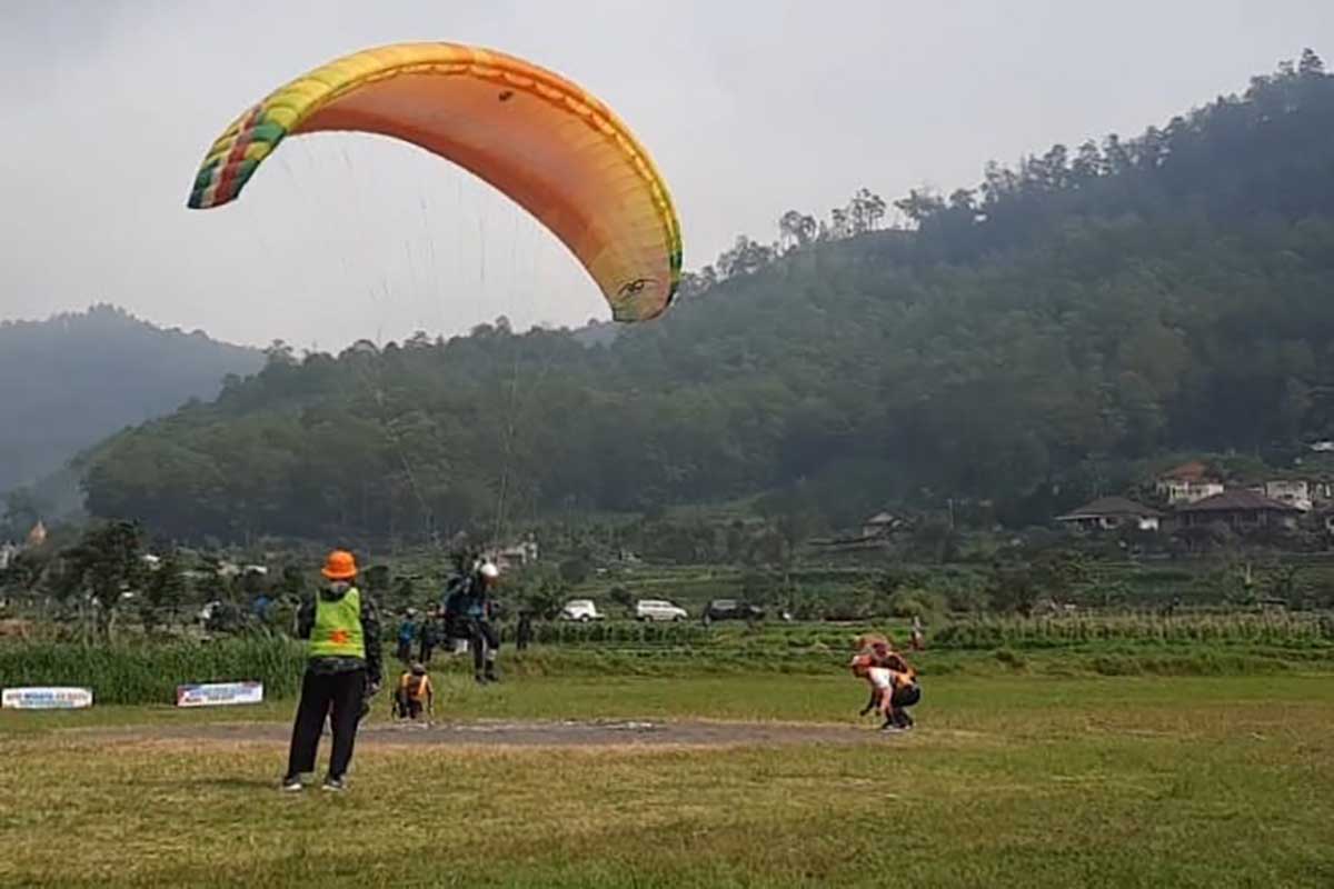 Salah satu atlet paralayang yang mencoba mendaratkan kakinya tepat di titik landing. (Seru.co.id/dik) - Ketum FASI Jatim Buka BISTF Paragliding Accuracy League 2024 dan IPAC 4th Series Disparta Batu
