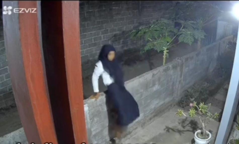 Tangkapan layar diduga maling CD sedang melakukan aksinya di rumah warga. (ist) - Heboh, Rekaman CCTV Maling CD Nyamar Jadi Wanita Berpakaian Seragam SMP di Jember