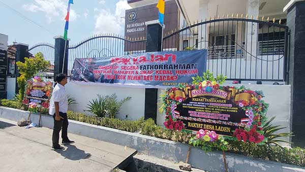 Karangan bunga dan bener yang membentang di depan Kejaksaan Negeri Pamekasan. (Seru.co.id/udi) - Apresiasi Kinerja Kejari Pamekasan, Warga Desa Laden Kirim Karangan Bunga Minta Segera Tangkap Fathor Rachman
