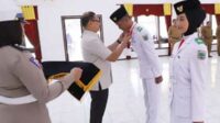 Pj Wali Kota Batu menyematkan tanda Purna Paskibraka kepada paskibraka kota Batu 2024. (ist) - Pj. Wali Kota Batu Tutup Masa Karantina Paskibraka Kota Batu Tahun 2024