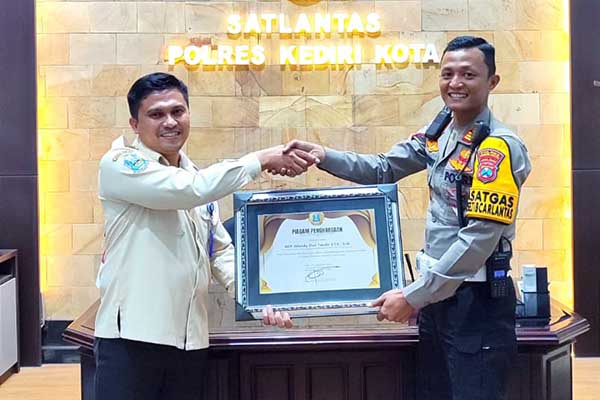 Piagam penghargaan yang diserahkan langsung oleh Kepala UPT Pengelolaan Pendapatan Daerah Kediri, Anang Noor Balquni, kepada Kasatlantas Polres Kediri Kota, AKP Afandy Dwi Takdir, Rabu (25/0/2024). (Seru.co.id/mam) - Berdedikasi di Penyelenggaraan Pelayanan di KB Samsat Kediri Kota, Kasatlantas Polres Kota Kediri Diganjar Piagam Penghargaan