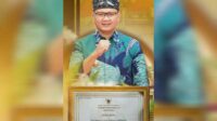 Pj. Wali Kota Batu memperlihatkan Piagam yang diterima oleh Pemkot Batu. (ist) - Kota Batu Berhasil Terapkan Sistem Merit dalam Tata Kelola Pemerintahan