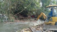 Proses pengerukan sampah pada aliran sungai, TKP korban dilaporkan hilang. (ist) - Pencarian Hari Ketiga Hilangnya Lansia Pencari Kayu Belum Buahkan Hasil