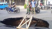 Babinsa Blimbing bantu evakuasi jalan Muharto amblas berlubang. (ist) - Babinsa Blimbing Bantu Evakuasi Jalan Muharto Amblas Berlubang