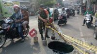 Babinsa Kotalama pasang rambu peringatan jalan amblas. (ist) - Babinsa Kotalama Pasang Rambu Peringatan Jalan Amblas