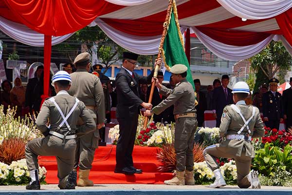 Serah terima Pataka Jer Basuki Mawa Beya Pj. Wali Kota Batu kepada Kasatpol PP Kota Batu. (ist) - Kirab Pataka Jer Basuki Mawa Beya Tiba di Kota Batu, Bawa Semangat Optimis Jatim Bangkit