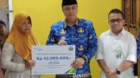 Pj Wali Kota Malang, Iwan Kurniawan menyerahkan, bantuan dari BPJS Ketenagakerjaan kepada istri almarhum. (ist) - Pj Wali Kota Malang Takziah dan Serahkan Bantuan Satlinmas Pilkada Meninggal Dunia