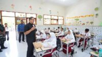 Pj. Aries saat memberikan edukasi minum susu di program uji coba makan siang bergizi gratis. (ist) - Pj. Wali Kota Batu Keliling Sekolah Lanjutkan Uji Coba Makan Siang Bergizi Gratis