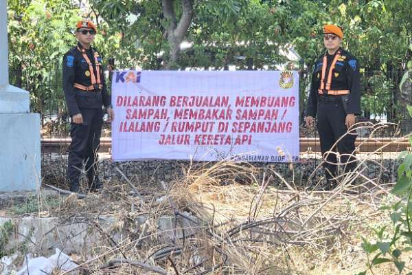 Polsuska memasang banner larang buang sampah di jalur kereta api. (ist) - KAI Daop 8 Surabaya Imbau Warga Tidak Buang & Bakar Sampah di Jalur KA