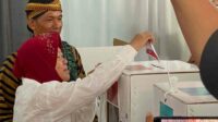 Kenakan Kerudung Merah, Cagub Tri Rismaharini Nyoblos di TPS 16 Jajar Tunggal Wiyung
