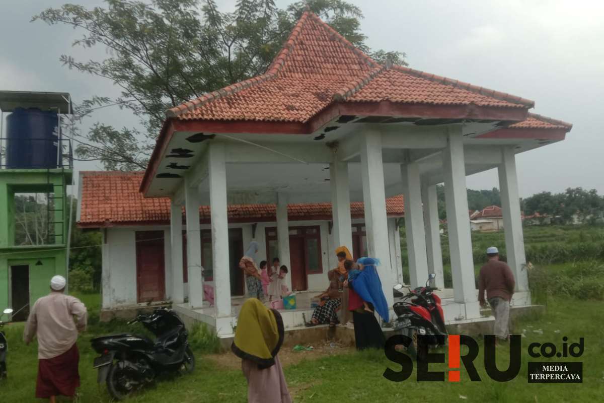 Terlihat warga berteduh saat hujan di balai desa Bulangan Barat yang mangkrak tak berfungsi. (Seru.co.id/udi) - Tiga Tahun Menunggu, Balai Desa Bulangan Barat Pamekasan Masih Tak Difungsikan
